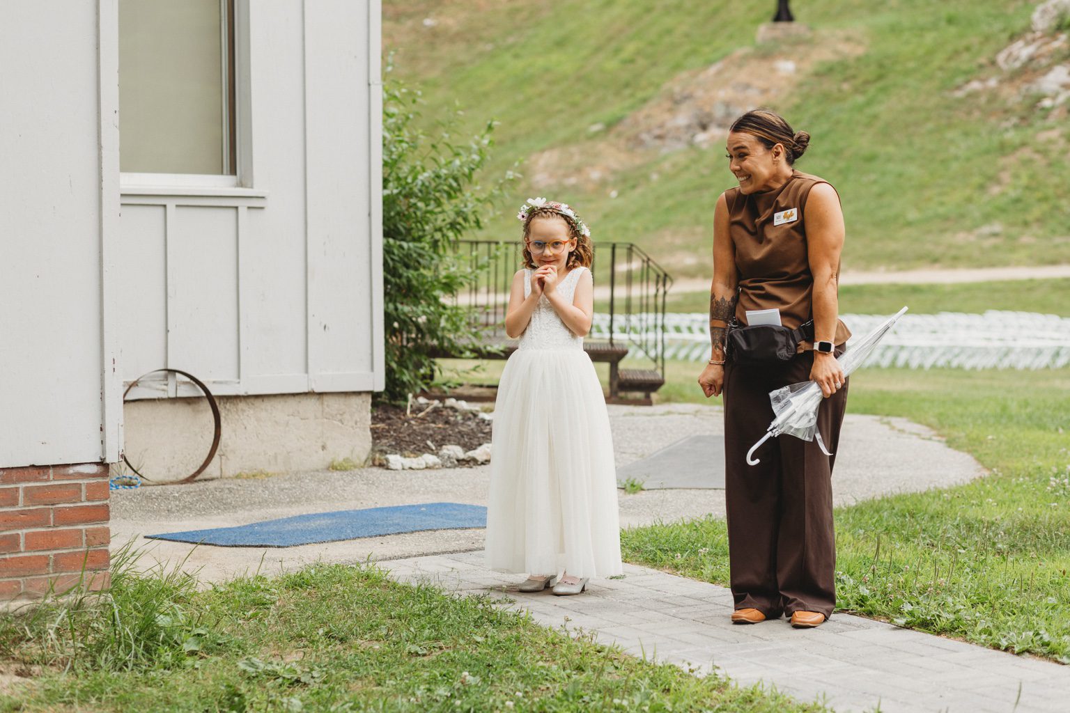 Kayla standing beside a young flower girl outside Lost Valley’s lodge